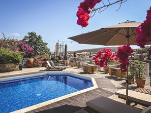Piscine extérieure, parasols de plage, chaises longues