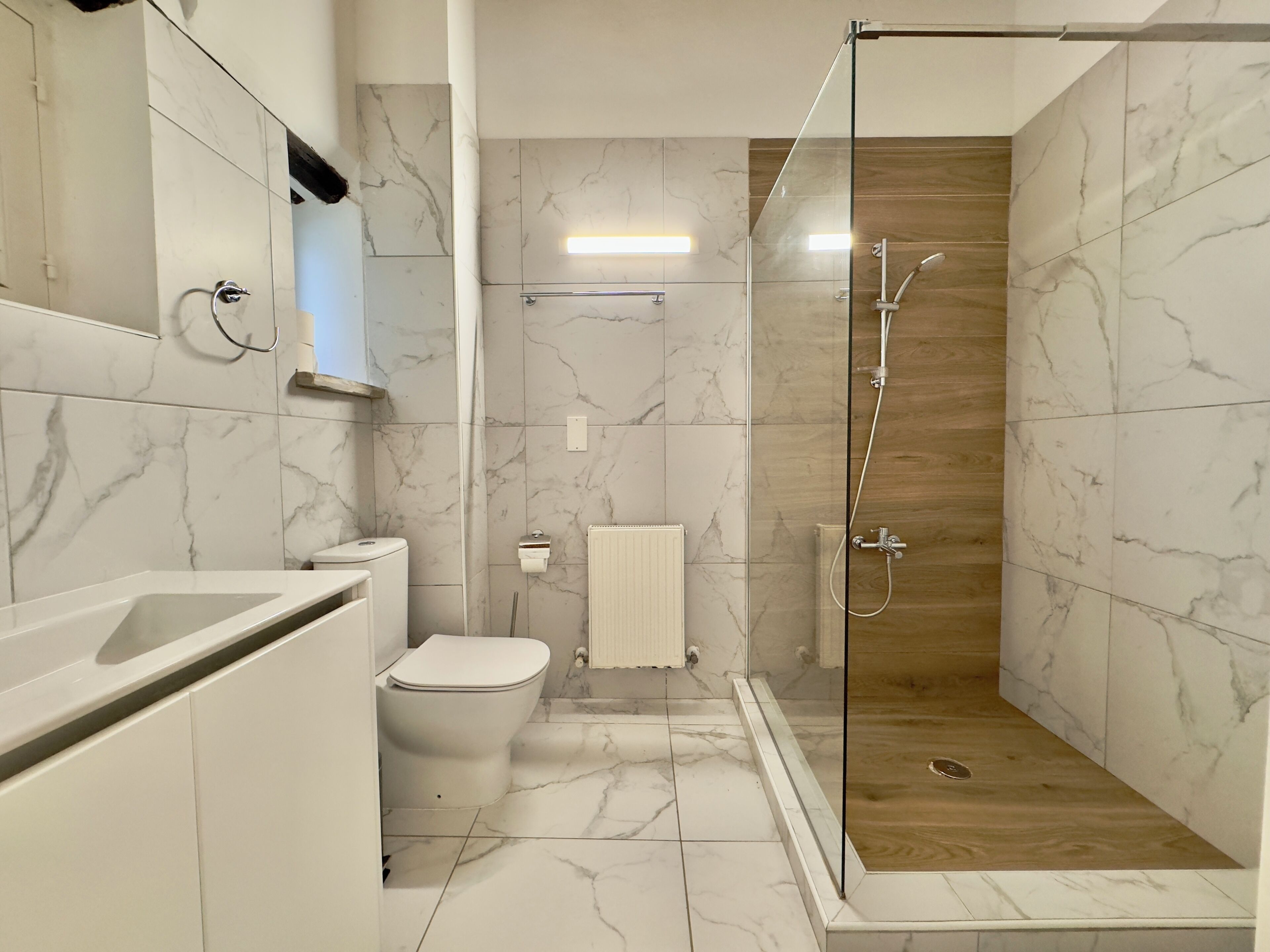 Ein modernes Badezimmer mit einer Duschkabine, einer Toilette und einem Waschbecken.