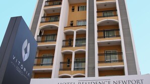 Un grand immeuble d’hôtel doté de nombreux balcons et d’une enseigne indiquant « Hôtel Residence Newport ».