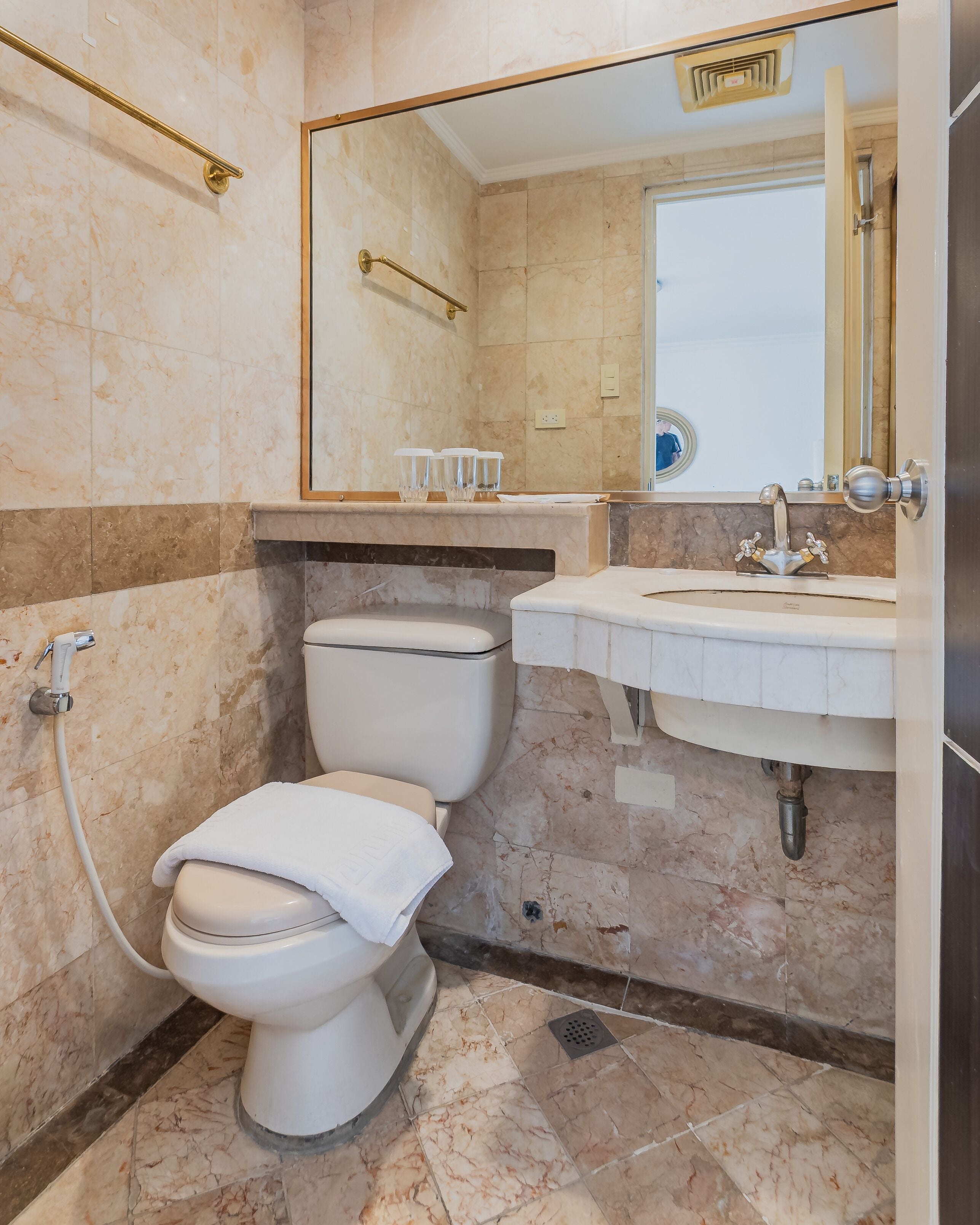 Un baño con inodoro, lavabo y espejo.