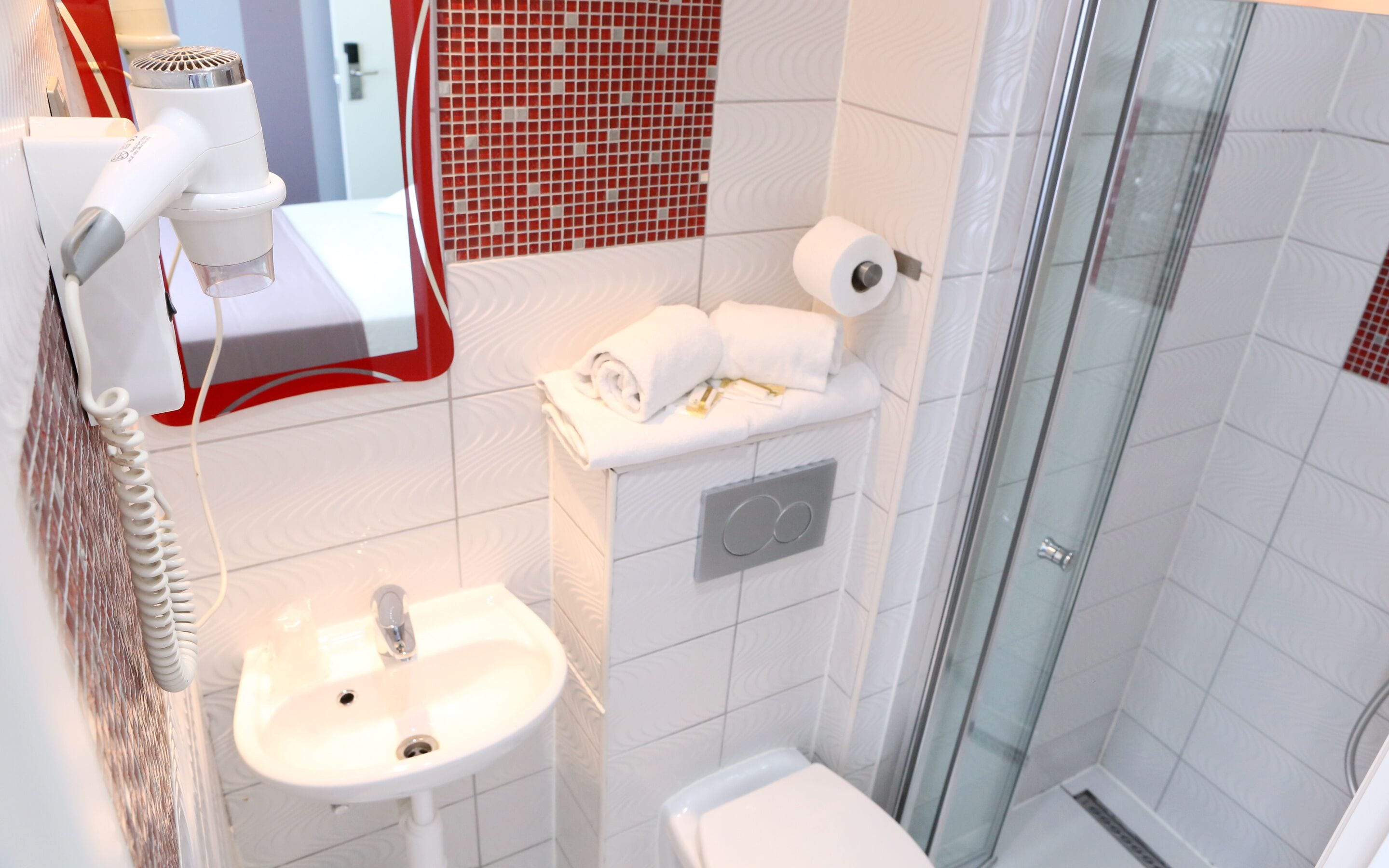 Une salle de bain avec un lavabo, des toilettes et une douche.