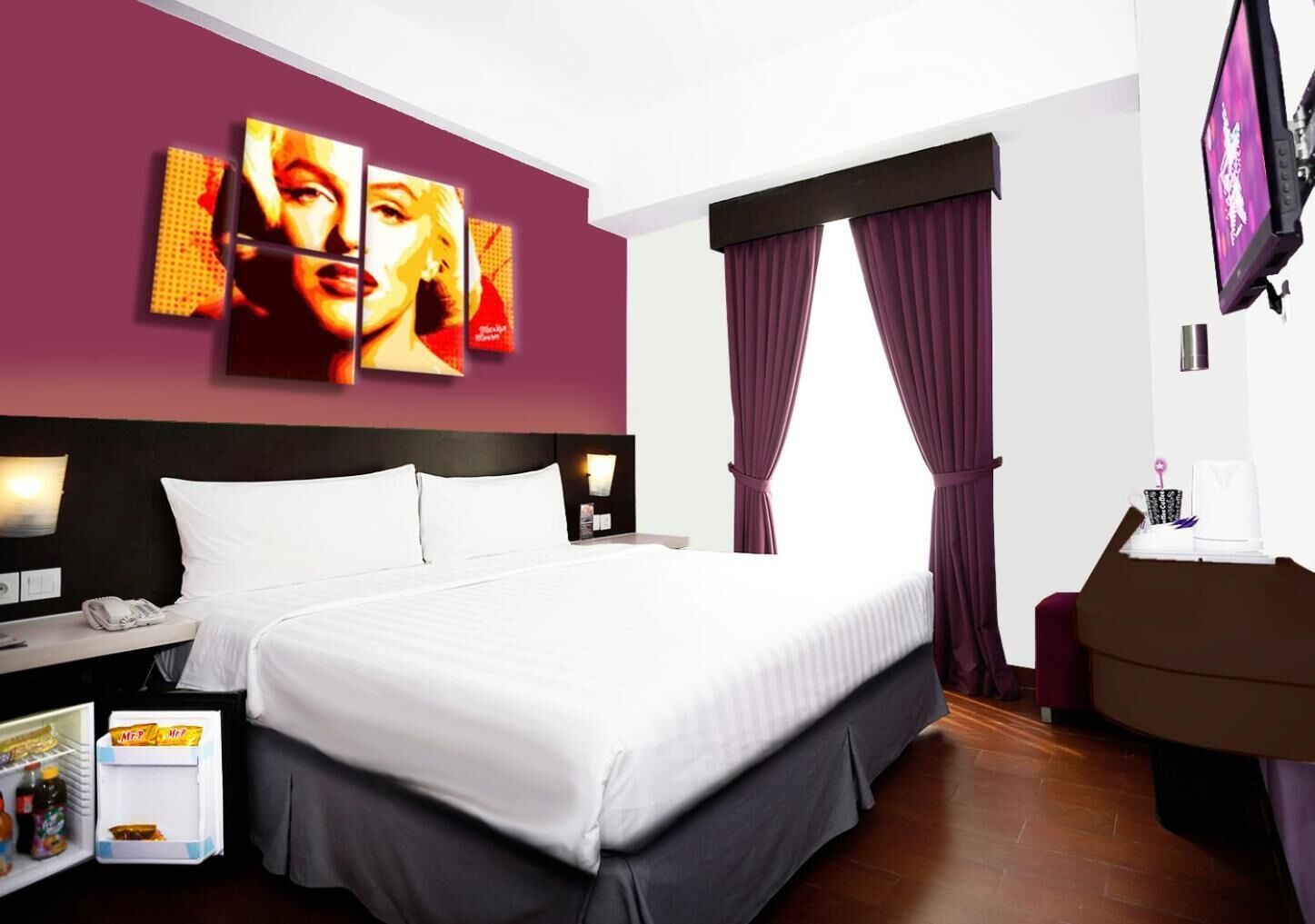 A modern hotel room with a large bed, a flat-screen TV, a desk with a chair, and a minibar.