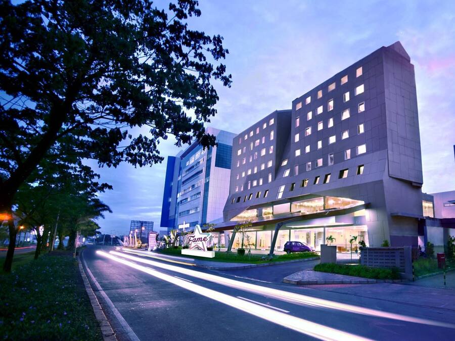 Un hotel moderno con un diseño arquitectónico único, que destaca por su entrada imponente y fachada bien iluminada.