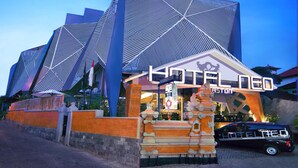 A modern hotel with a distinctive geometric facade and a traditional decorative entrance. - Hotel Neo Kuta Jelantik (Legian)
