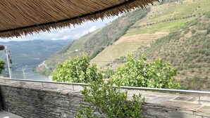 Una mesa preparada para el desayuno con vistas a colinas ondulantes y un río.