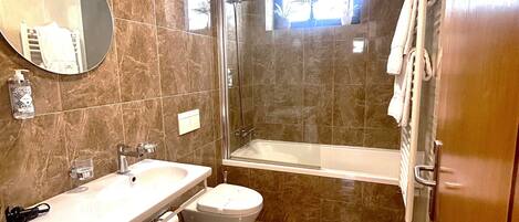 A modern bathroom with a sink, toilet, bathtub, and a shower stall.