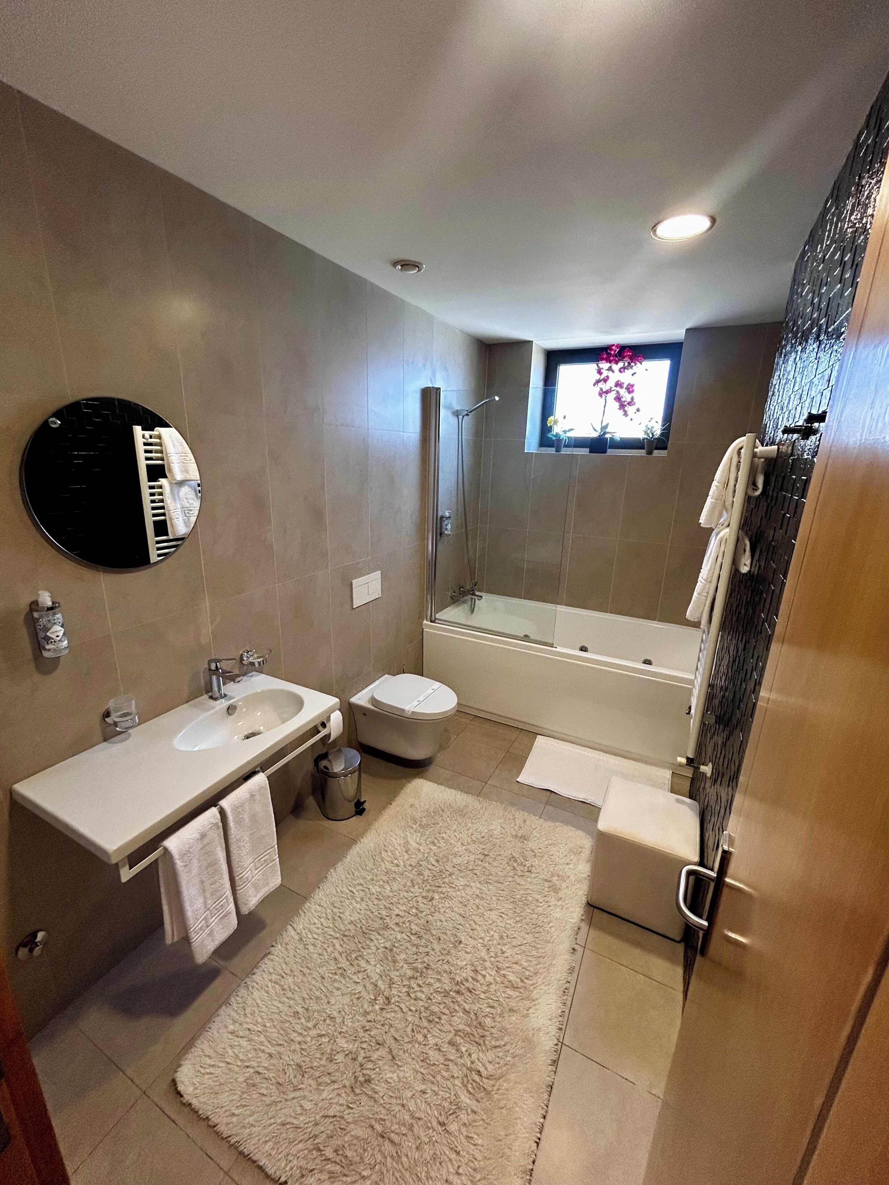 Une salle de bain moderne avec un lavabo, des toilettes et une baignoire.