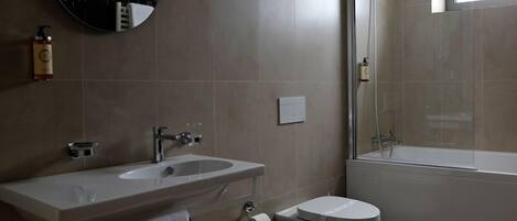 A modern bathroom with a sink, toilet, and bathtub.