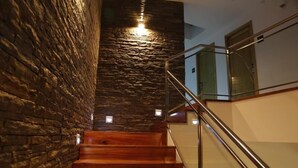 Una escalera con escalones de madera y un muro de piedra a un lado.