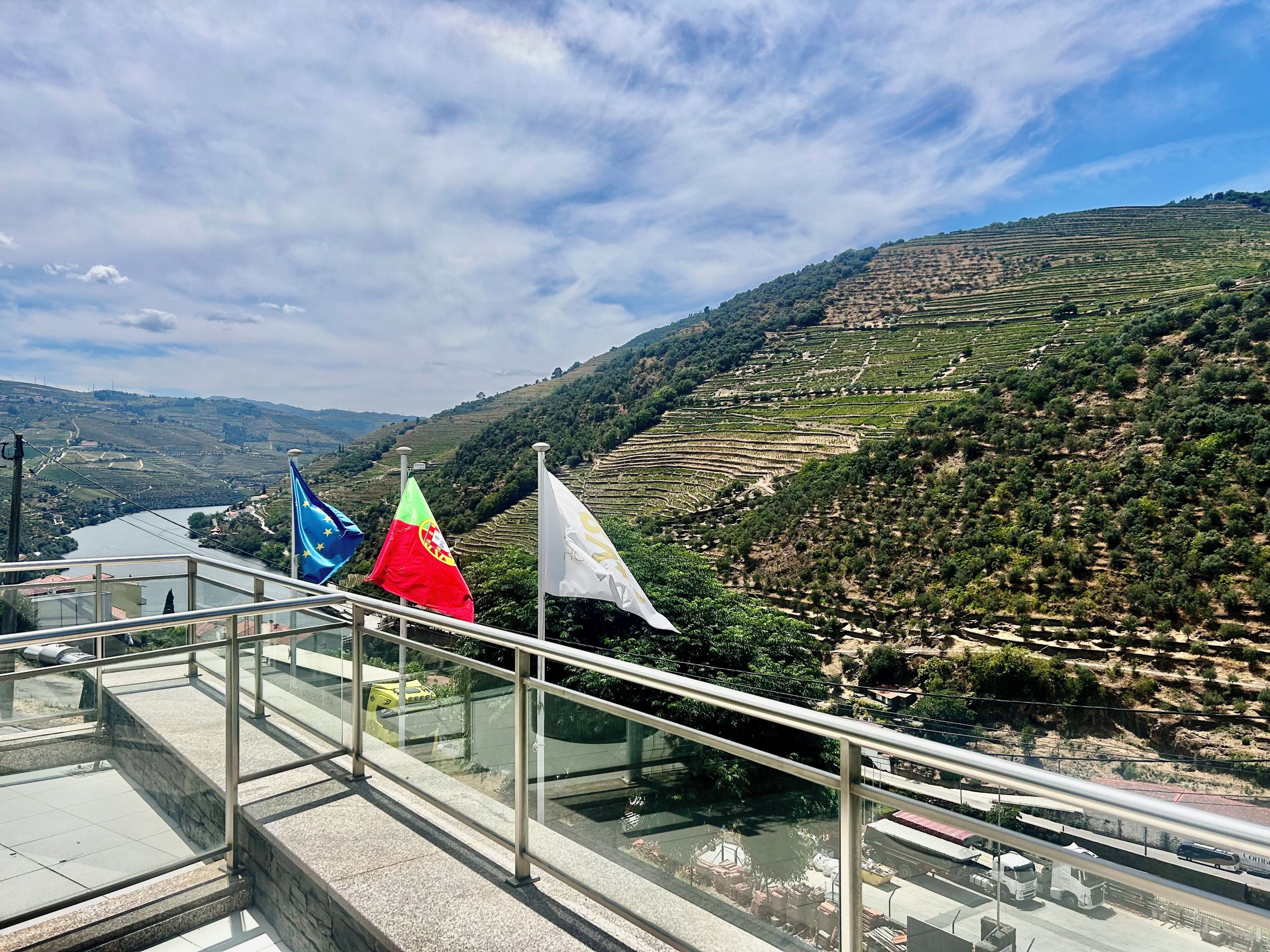 A terrace with a view of terraced vineyards and a river.