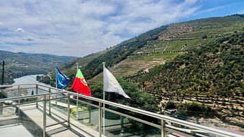 Eine Terrasse mit Blick auf terrassenförmig angelegte Weinberge und einen Fluss.