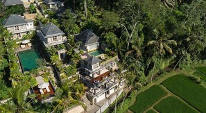 A large, multi-story house with a swimming pool, surrounded by lush greenery and palm trees. - Jiwa Klusa Luxury Villa (Payangan)