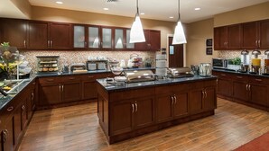 Une cuisine moderne avec des meubles en bois, un grand îlot central et divers appareils électroménagers.