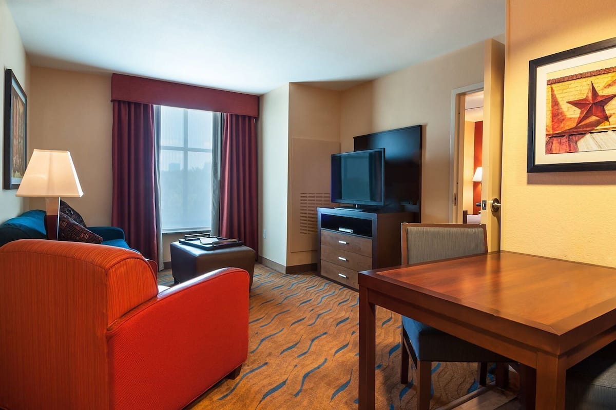 Une chambre d’hôtel avec un lit, une télévision, un bureau et une chaise.