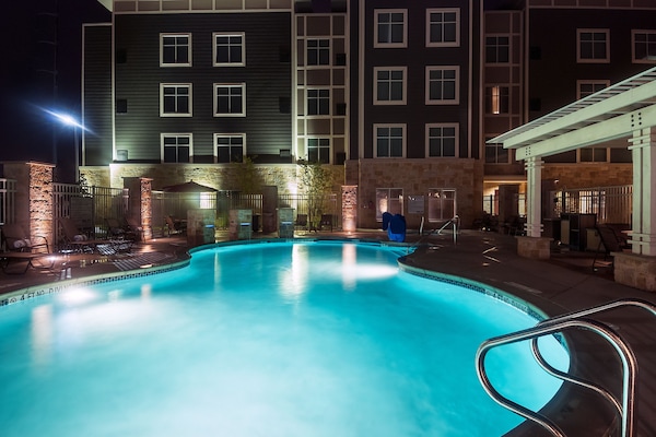 Una piscina al aire libre, sillones reclinables de piscina