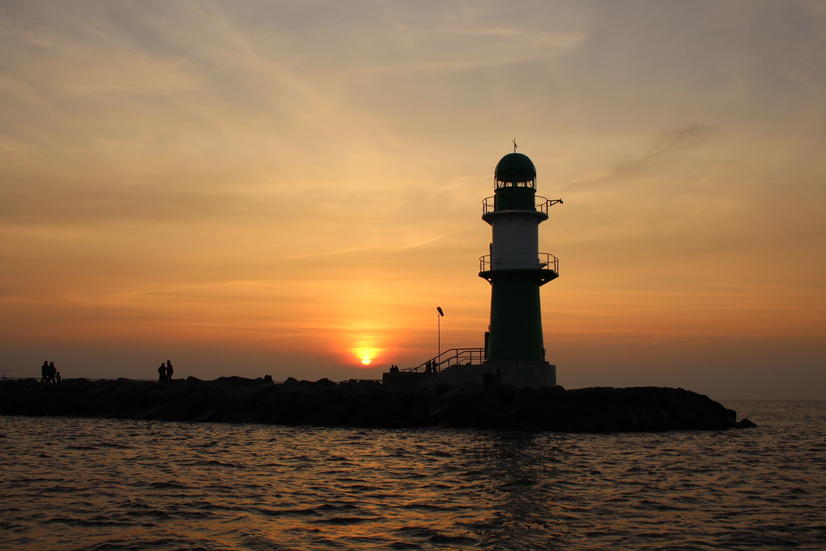 A lighthouse silhouette against a sunset.