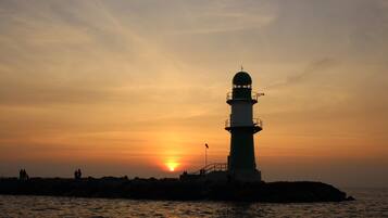 A lighthouse silhouette against a sunset.