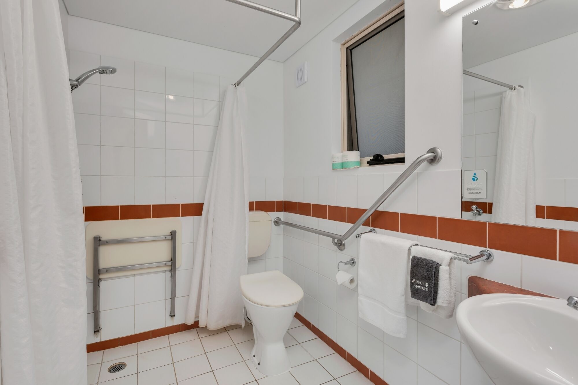 Une salle de bain avec des toilettes, une douche et un lavabo.