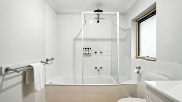 Une salle de bain moderne avec une douche à parois de verre, une baignoire blanche, des toilettes et un lavabo.