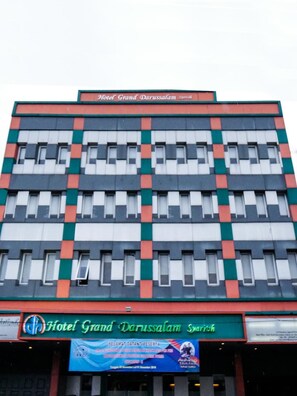 A multi-story hotel building with a prominent sign reading 'Hotel Grand Darussalam Syariah' at the ground level. - Grand Darussalam Syariah Hotel (Medan)