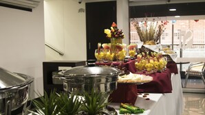 A buffet table with various food items and a decorative centerpiece. - Hotel El Portón de San Joaquín (Medellín)