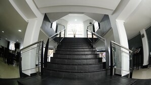 A modern staircase with glass railings and a view of the outside. - Hotel El Portón de San Joaquín (Medellín)