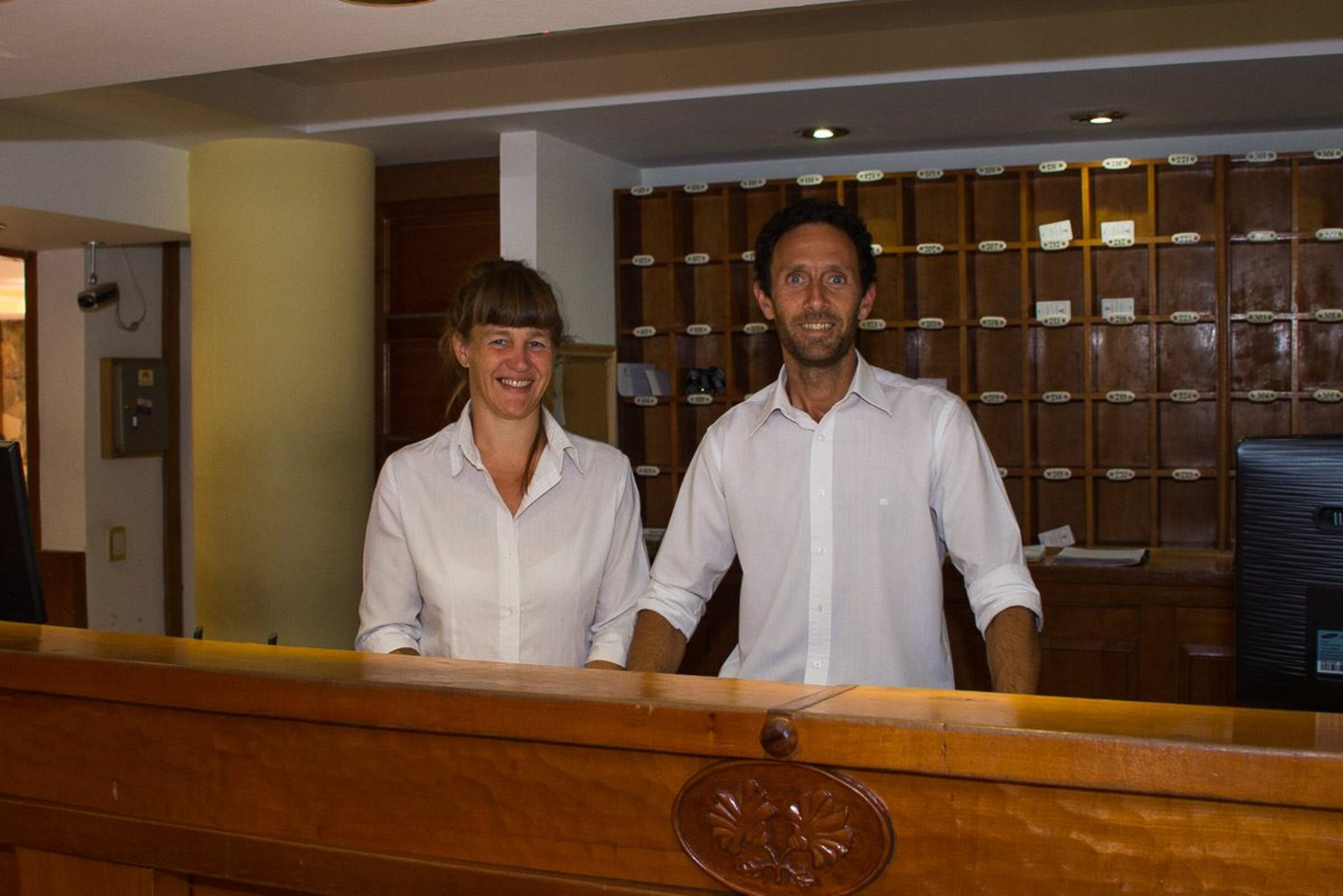A reception area with a wooden counter and a wall of numbered storage boxes.