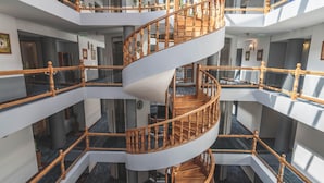 Un interior de varios niveles con una escalera espiral central.