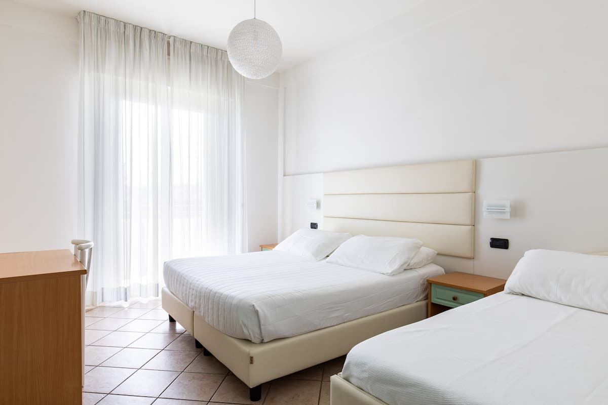 Driepersoonskamer, gedeeltelijk uitzicht op zee | Een kluis op de kamer, een bureau, gratis wifi, beddengoed