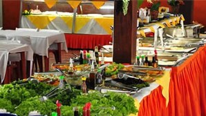 A buffet setup with multiple tables covered in white tablecloths, featuring various food items and condiments. - Hotel Fazenda 3 Poderes (Caraguatatuba)