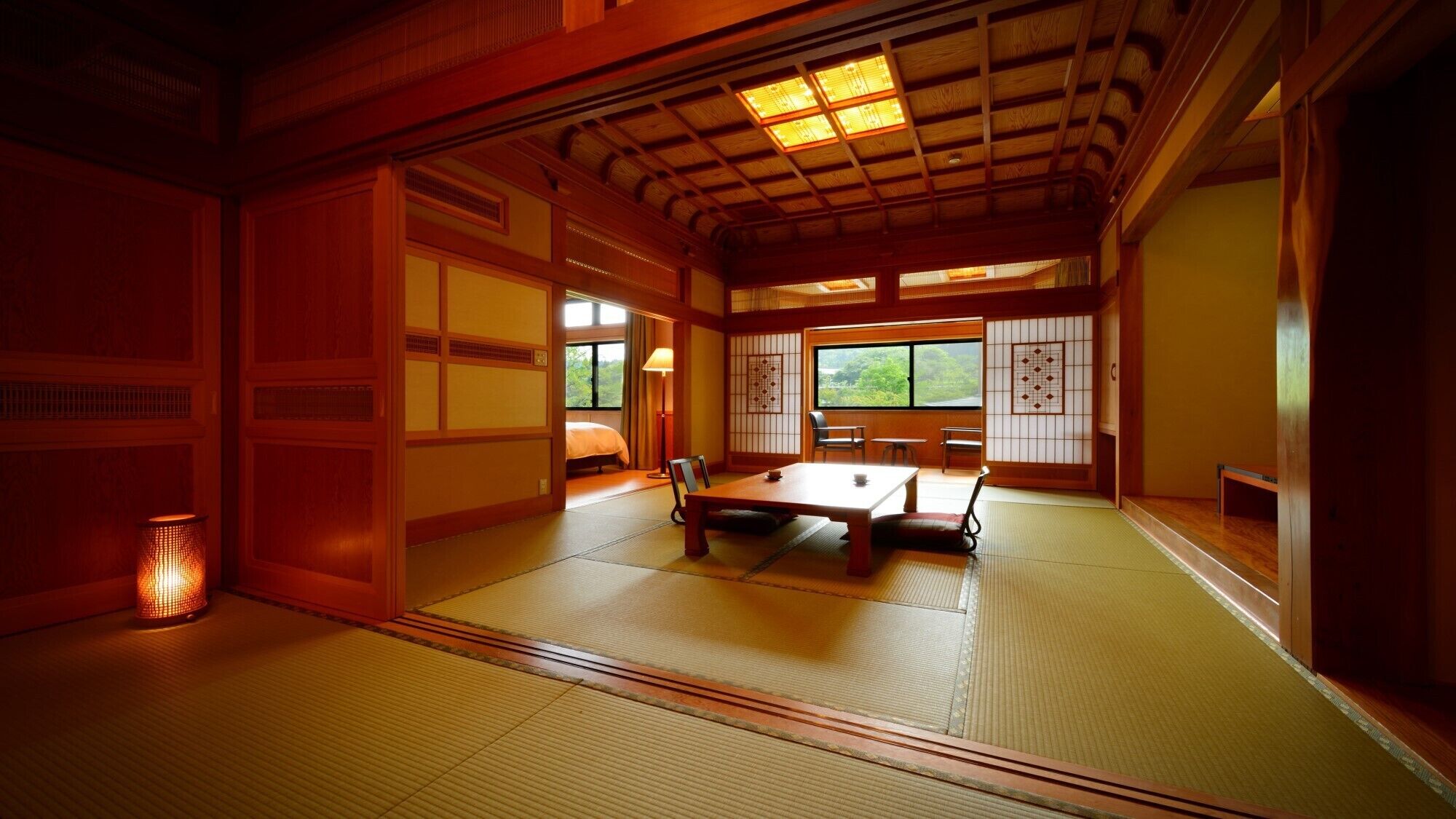 Una habitación japonesa tradicional con suelo de tatami, una mesa baja y puertas correderas.