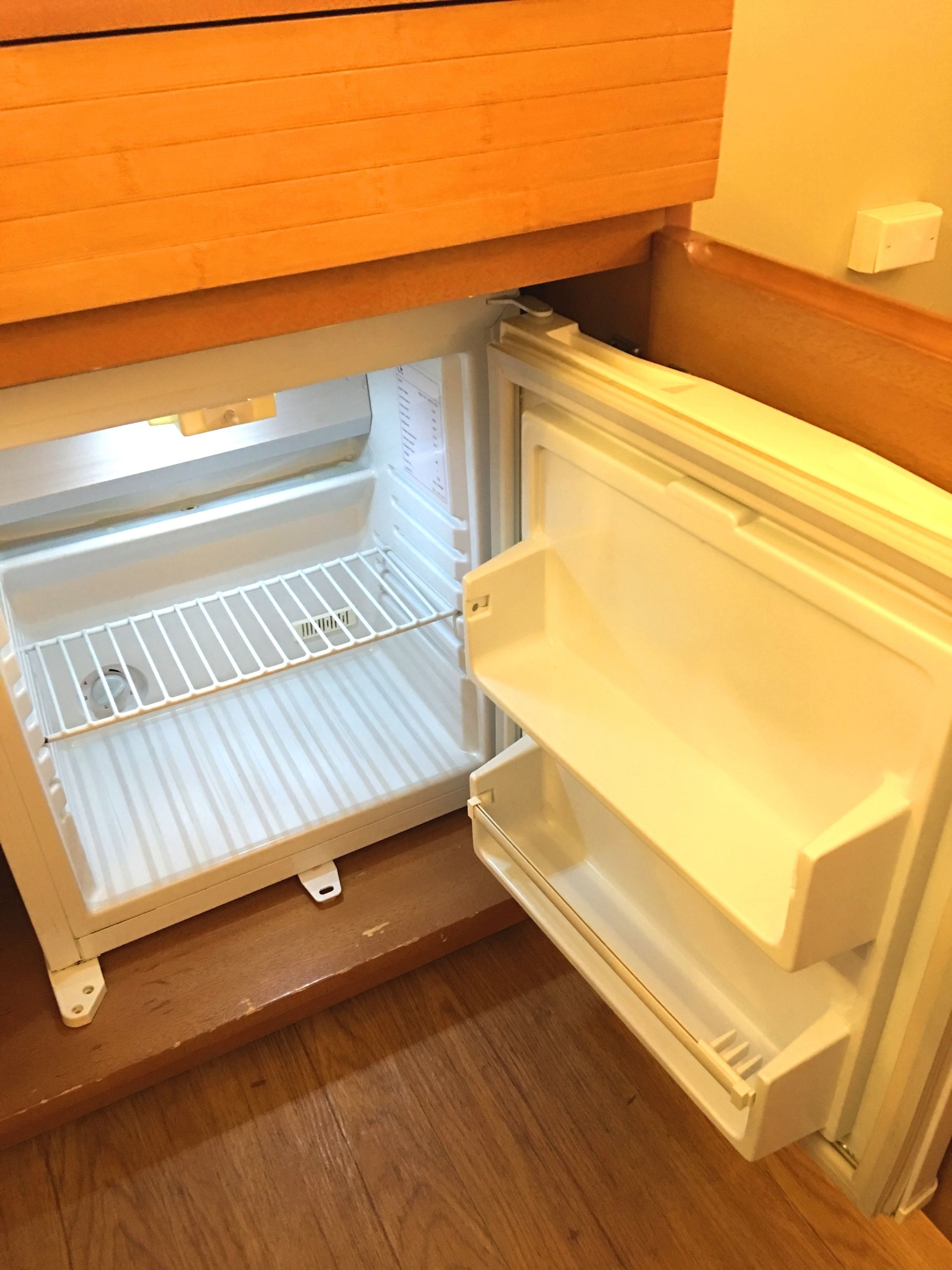An open refrigerator with two shelves and a freezer compartment.