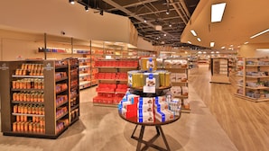 A spacious retail store with neatly organized shelves and a central display table. - Guam Plaza Resort (Tamuning)