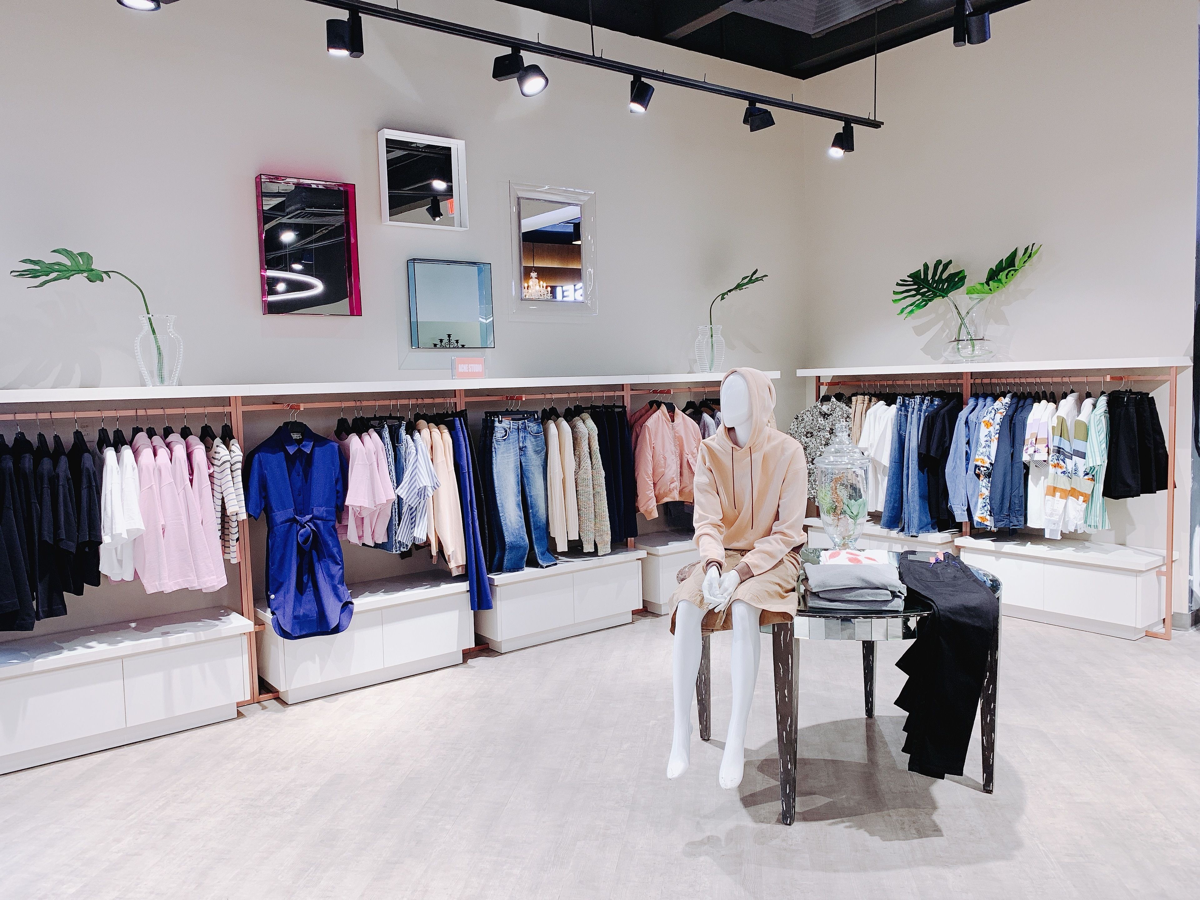 A clothing store with mannequins and racks of clothes.