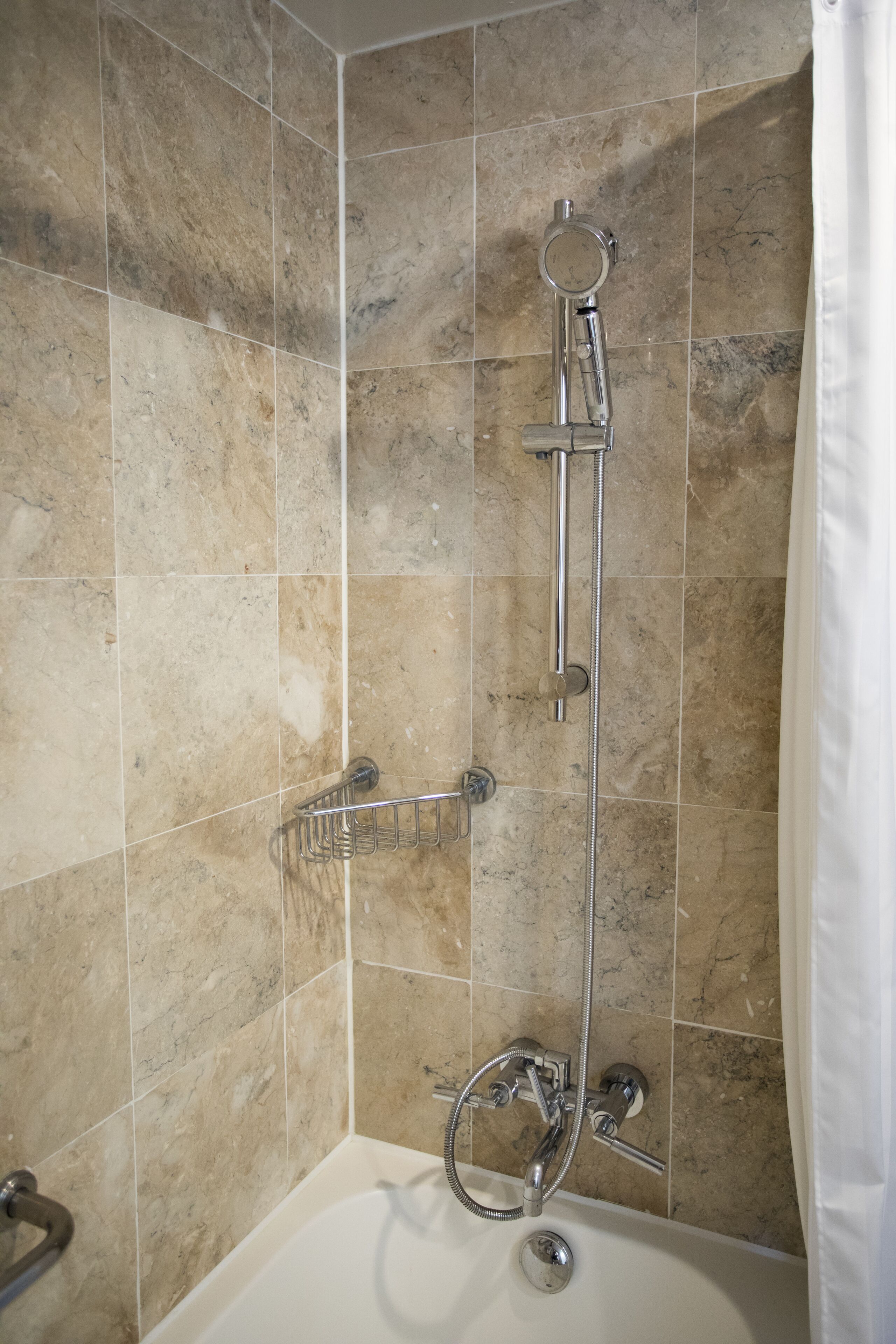 A bathroom with a shower, a bathtub, and a towel rack.