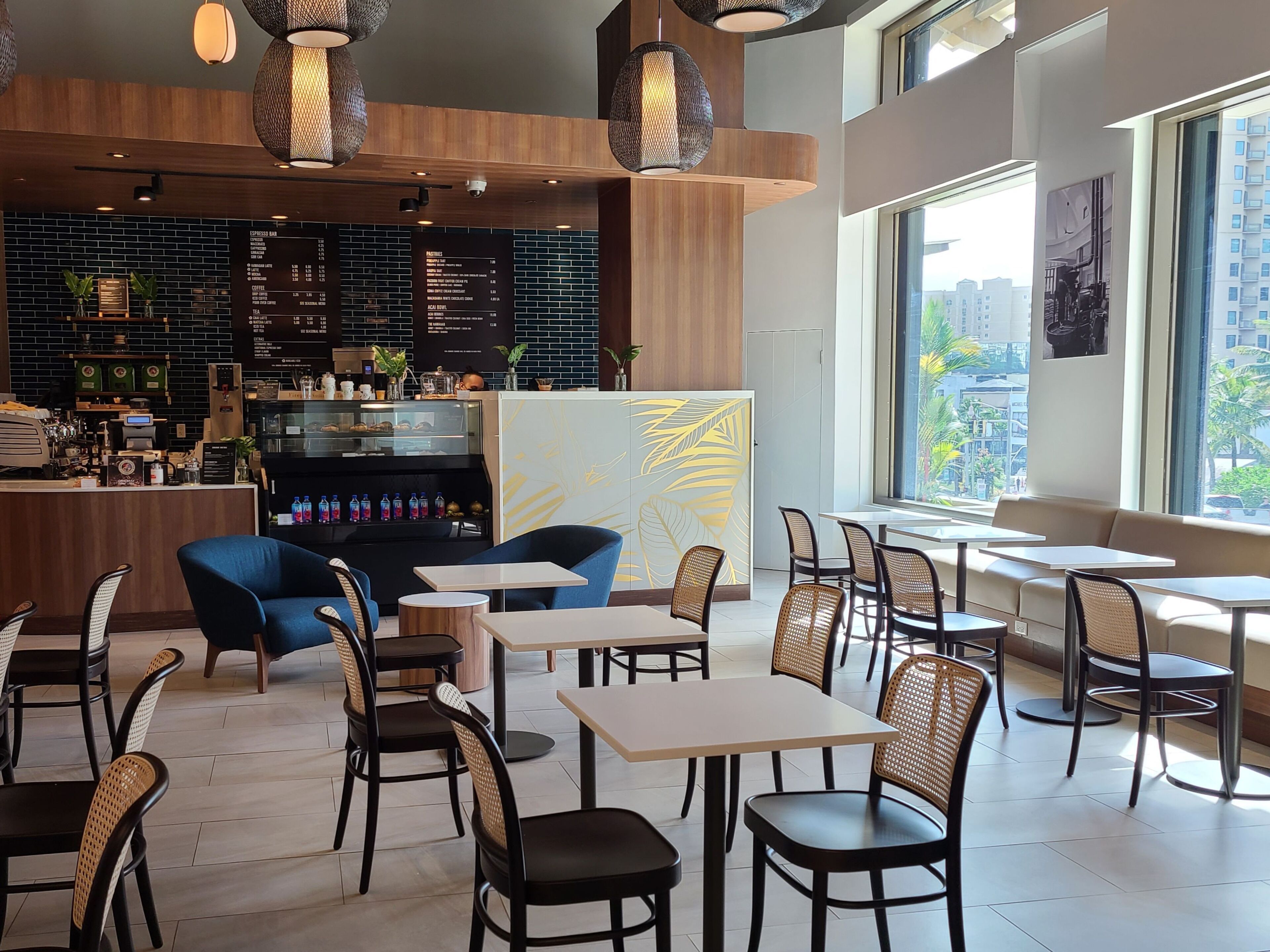 A modern cafe with a bar area, seating arrangements, and a menu board.