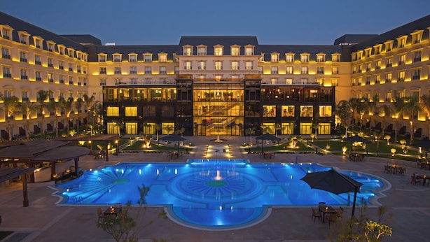 A hotel with a large central pool, multiple balconies, and a well-lit facade. - Renaissance Cairo Mirage City Hotel (New Cairo)