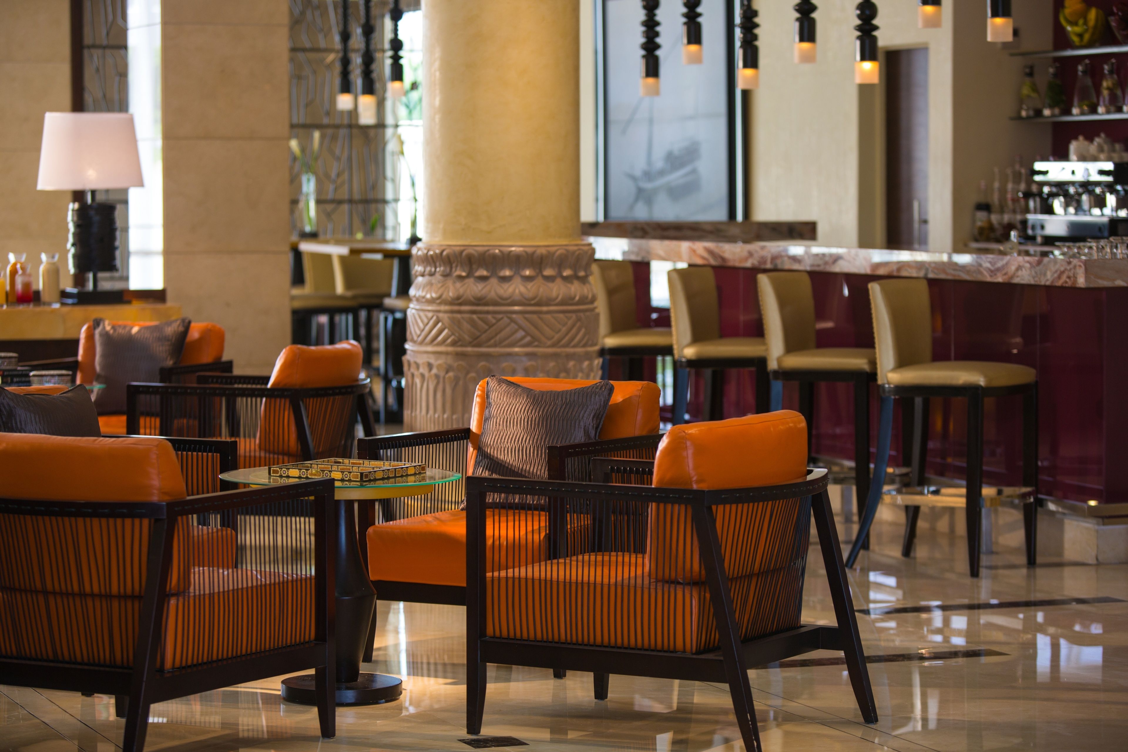 A lobby with seating areas, a bar, and a large pillar.