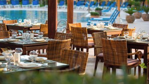 A restaurant with tables set for dining, overlooking a pool area with lounge chairs. - Renaissance Cairo Mirage City Hotel (New Cairo)