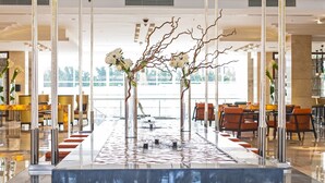 A modern lobby with a reflective water feature, seating areas, and a glass facade. - Renaissance Cairo Mirage City Hotel (New Cairo)