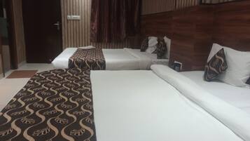 A hotel room with two beds, a patterned carpet, and a wooden headboard.