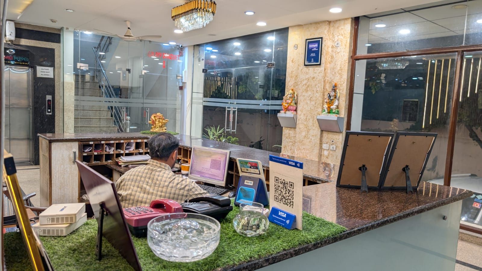 A reception desk with a computer, a phone, and a QR code for payment.