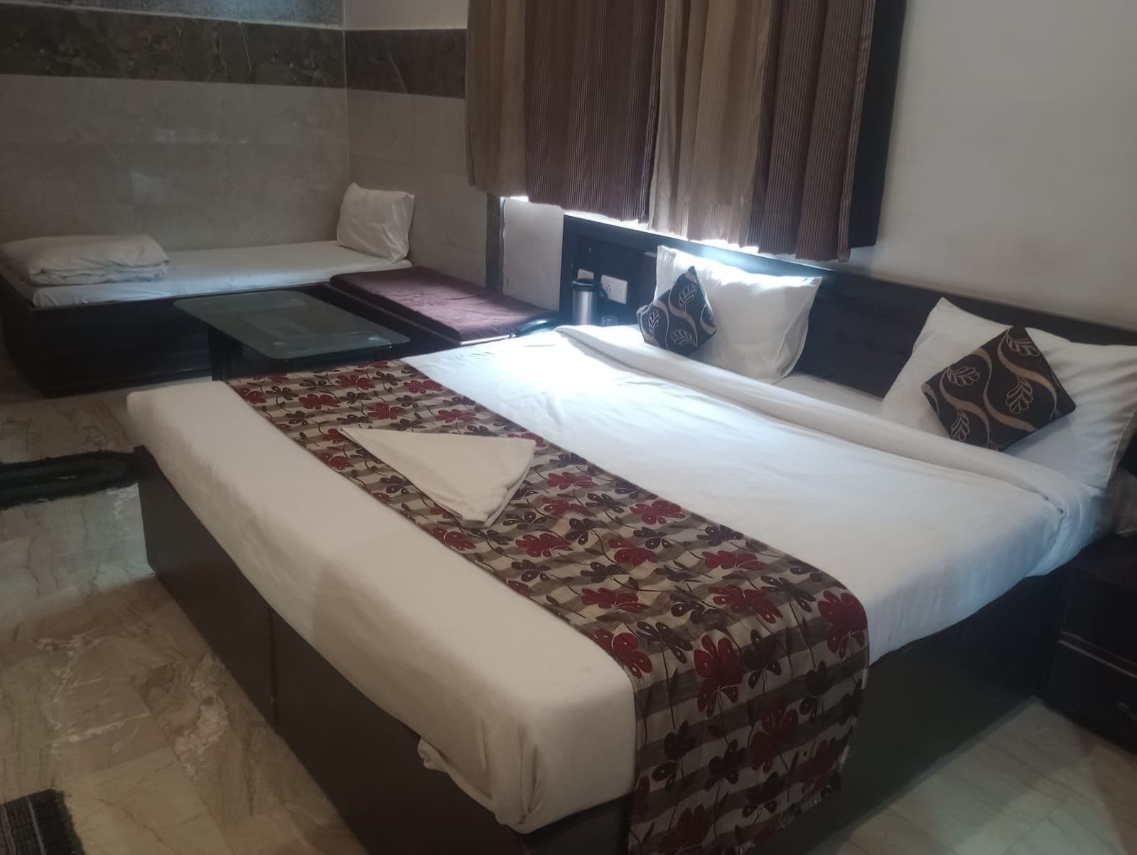 Una habitación de hotel con una cama grande, un sofá y una mesita.