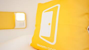 Un coixí groc amb un logotip de porta blanca i el text