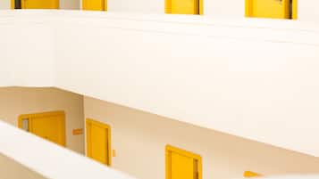 Un interior con varios niveles, puertas amarillas y una pared blanca.