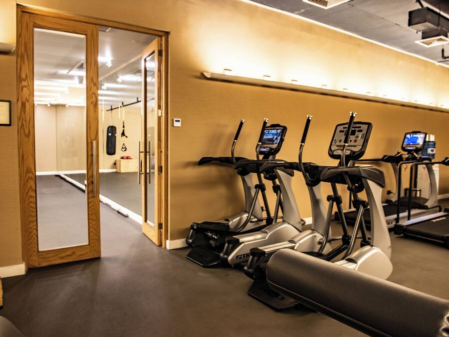A gym with exercise equipment, a wooden door, and a mirror.