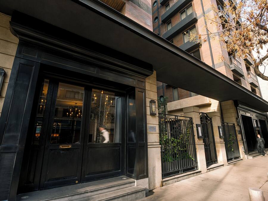A building with a black entrance, large windows, and a stone facade.