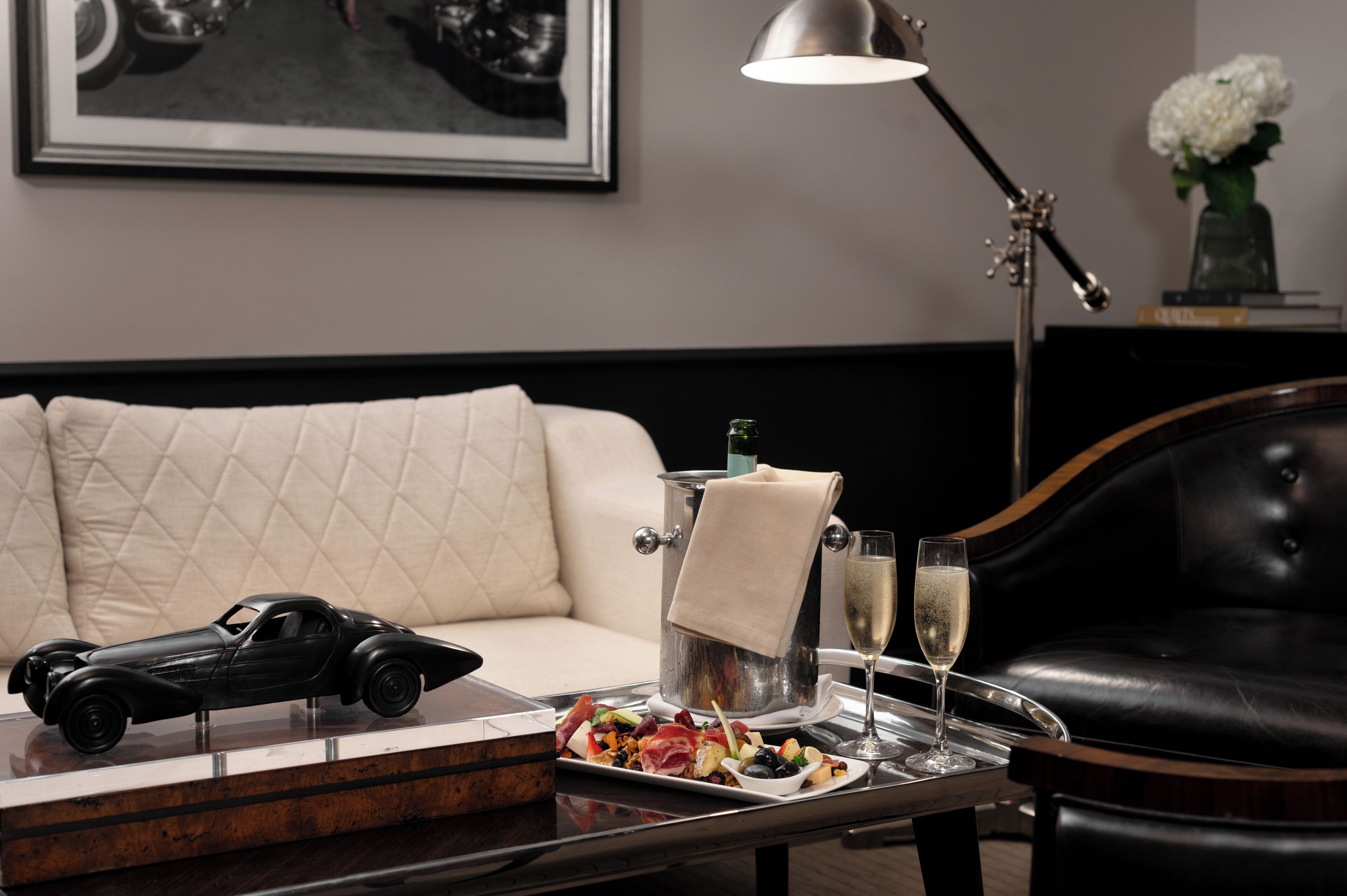 A dining table with a car model, a hot tub, and a glass of champagne.