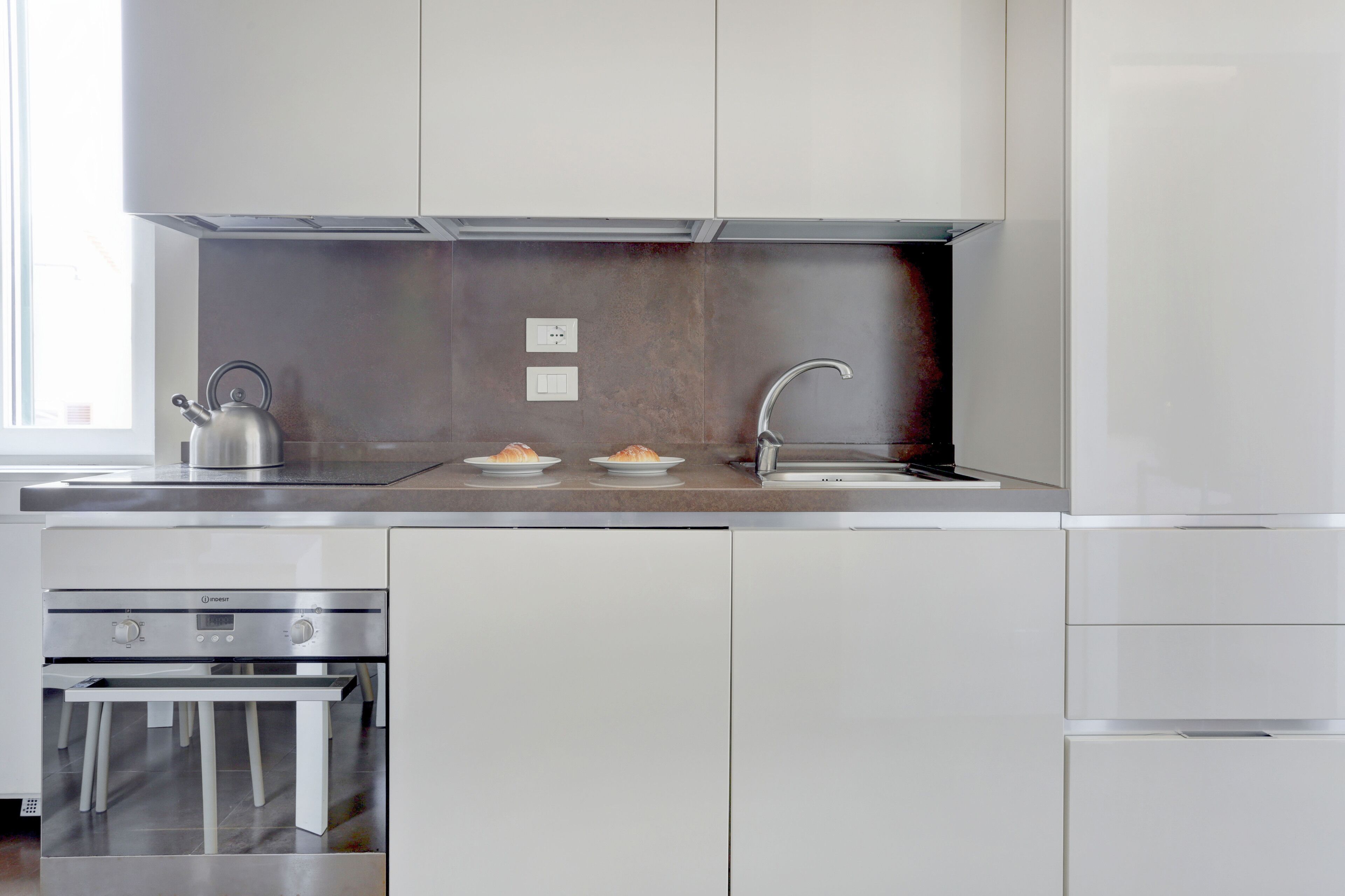 Une cuisine moderne équipée d’appareils électroménagers en acier inoxydable, d’un four encastré et d’un évier.