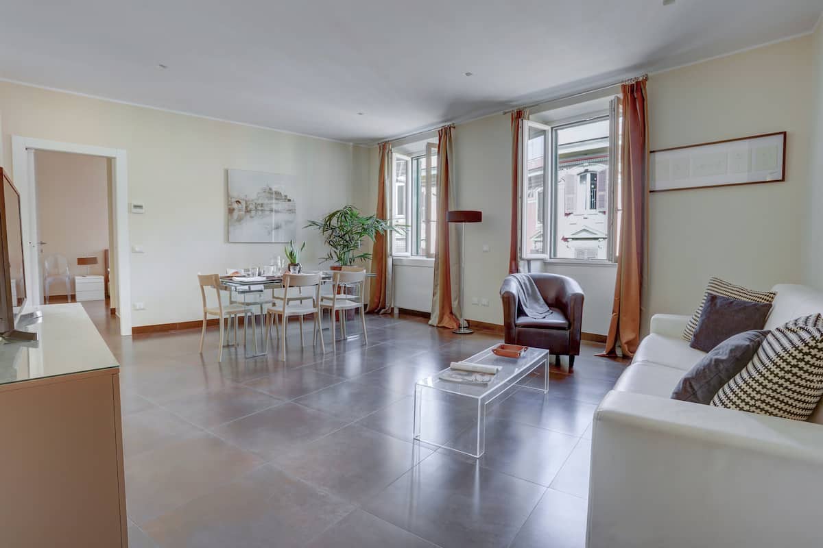 A spacious living area with a dining table, chairs, a sofa, and a coffee table.
